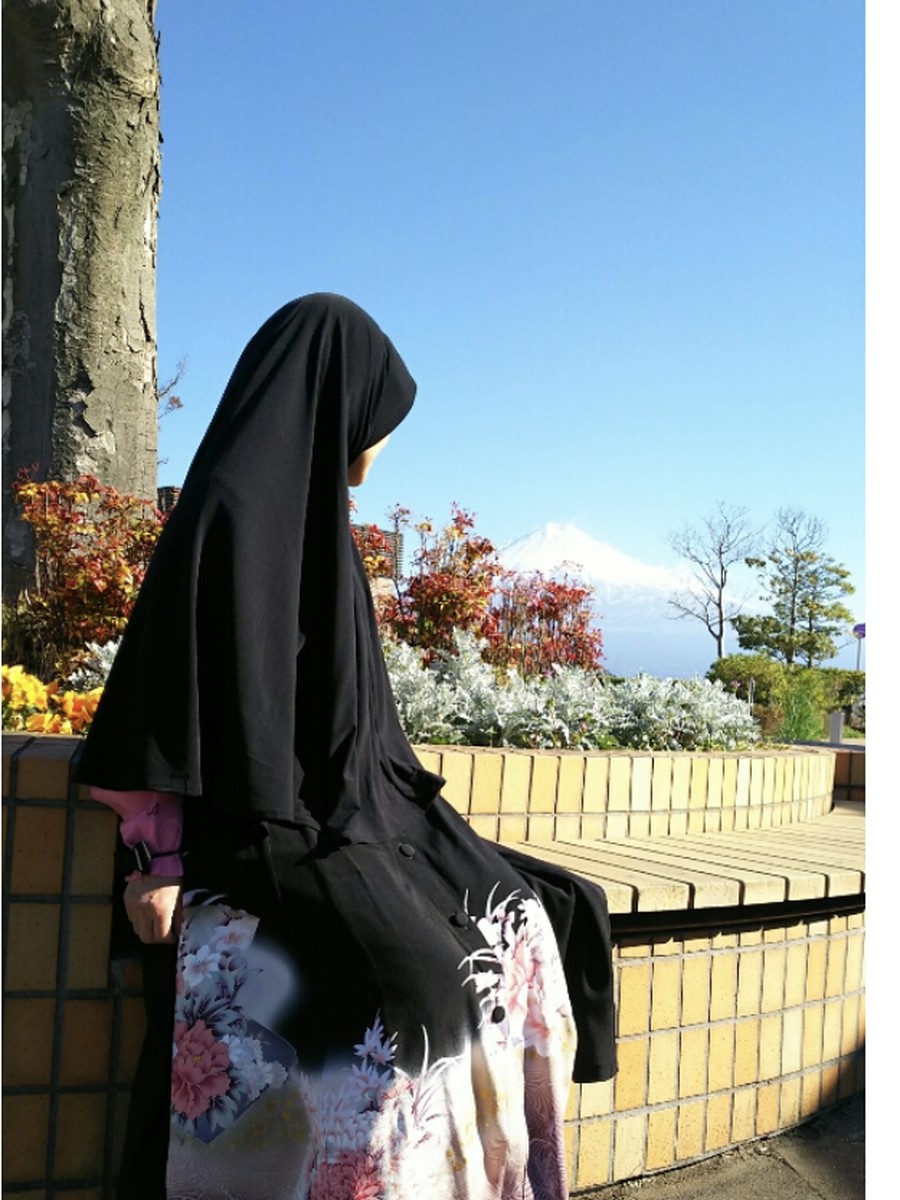 S. wearing a long cardigan and hijab