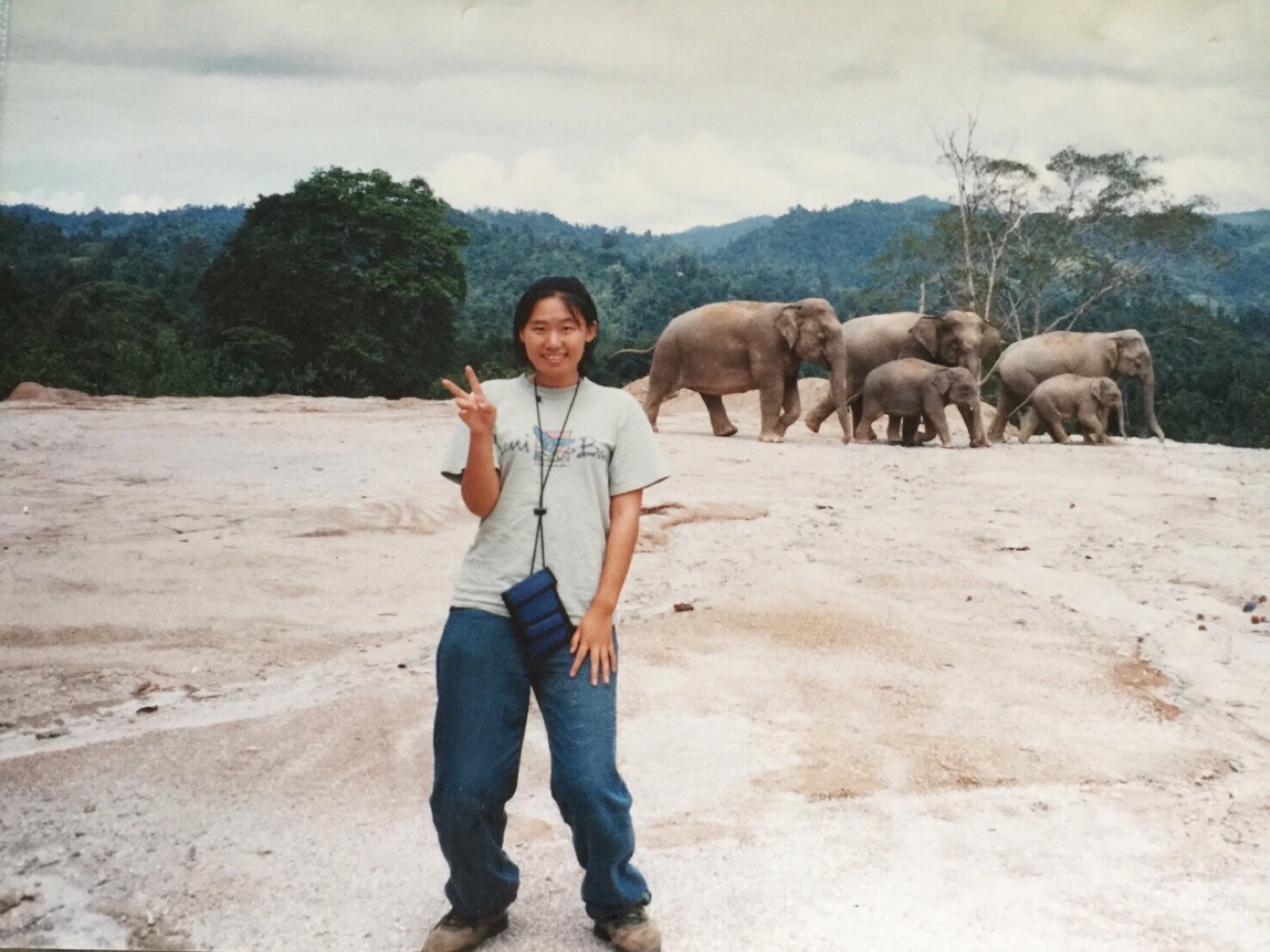 マレーシアのジャングルで野生の象と並んで立つ若き日の筆者